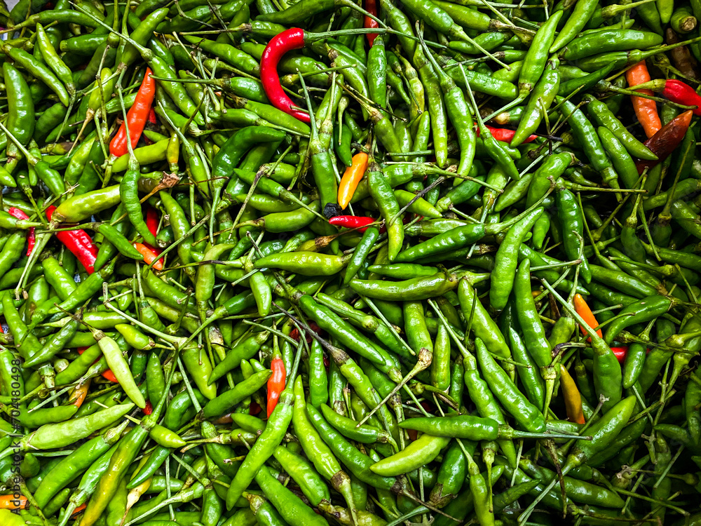 Backdrop of green chilli peppers texture background. Close up view with copy space for design