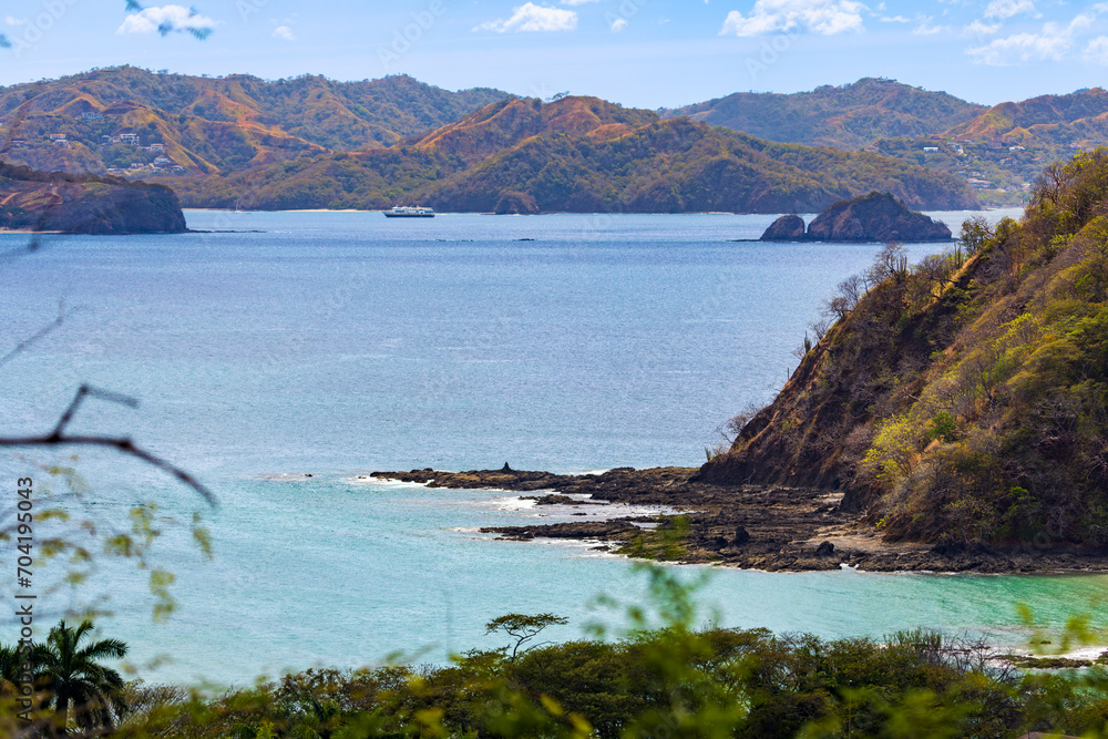 Fototapeta premium view of coastline and a small yacht in the waters, Papagayo Peninsula, Costa Rica