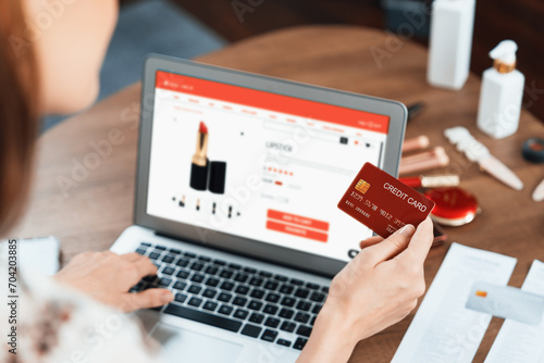 Woman shopping online on internet marketplace browsing for sale items for modern lifestyle and use credit card for online payment from wallet protected by utmost cyber security software