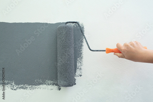Roller Brush Painting, Worker painting on surface wall  Painting apartment, renovating with grey color  paint. Leave empty copy space white to write descriptive text beside.