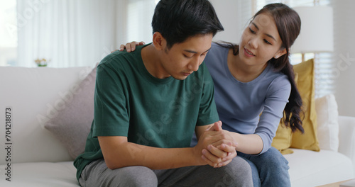 Asia young people stress relief trust talk share suffer cancer pain sick family loss bad news crisis. Sorrow cry man and carer woman sit at sofa home help listen by love hold hand warm hug touch wife. © ChayTee