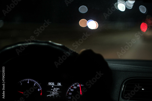 Driver holding steering wheel and driving on highway at night photo