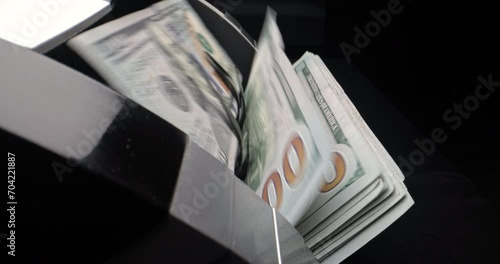 Counting machine counts American dollar bills. Slow motion with maximum magnification allows you to see small details on bank notes. Dollar bills are counted. Managing money for business purposes.