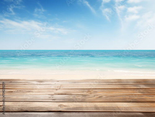 An empty wooden dock overlooking a beach with the ocean in the background,