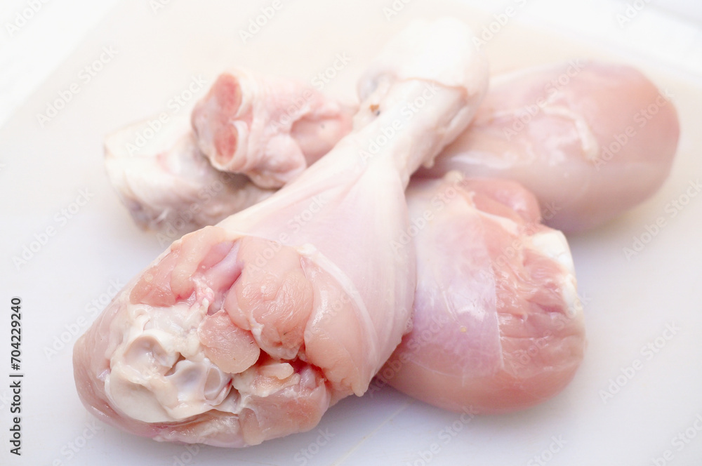raw chicken thighs in white cutting board raw chicken thighs in white cutting board