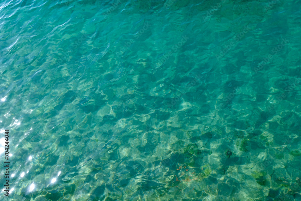 Clean transparent sea water, lake bottom and sand. Beautiful blue, turquoise transparent surface Clean transparent sea water, lake bottom and sand. Beautiful blue, turquoise transparent surface