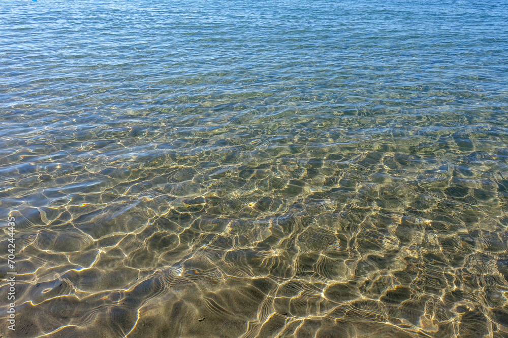 Clean transparent sea water, lake bottom and sand. Beautiful blue, turquoise transparent surface Clean transparent sea water, lake bottom and sand. Beautiful blue, turquoise transparent surface
