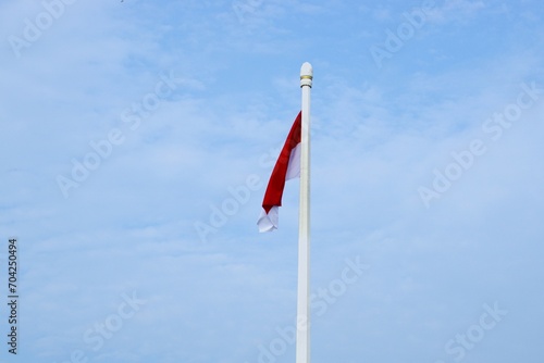 Indonesian flag at tall pole and blue sky