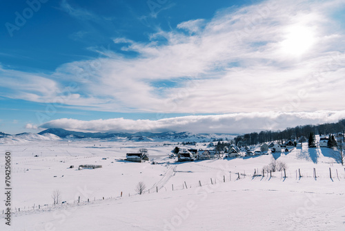 Snow-covered village in a mountain valley in bright sunshine