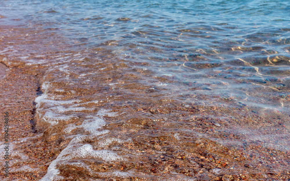 Clean transparent water, wave on the sand. Coastline. Kyrgyzstan, Lake Issyk-Kul. natural background.