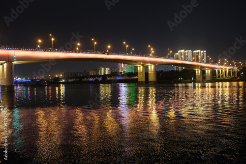 Nanning city,Guangxi province, China at night. Bridge over Yong River with reflection