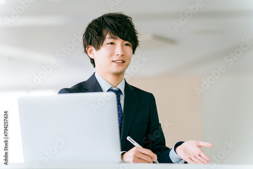 ノートパソコンを使い提案する若いビジネスマン
 photo