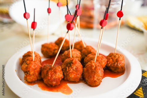 Meatballs on skewers with tomato sauce. photo