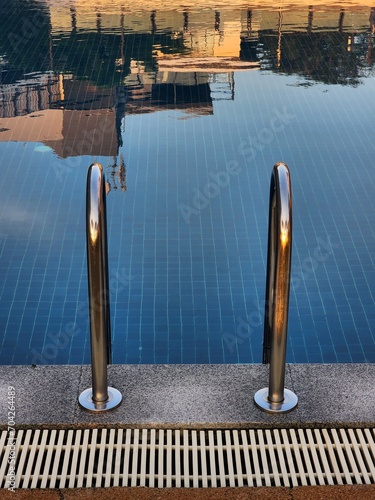 Peaceful and relax swimming pool with metal handrail with slient surface swimming pool photo