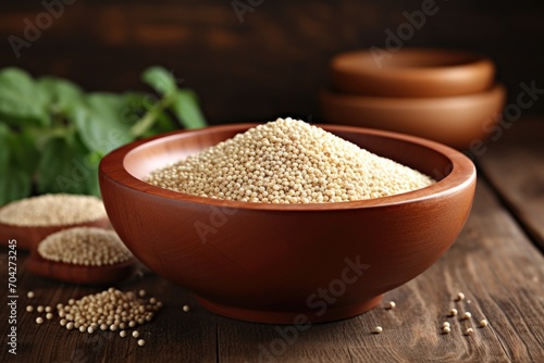 Quinoa in bowl on wooden kitchen table. photo