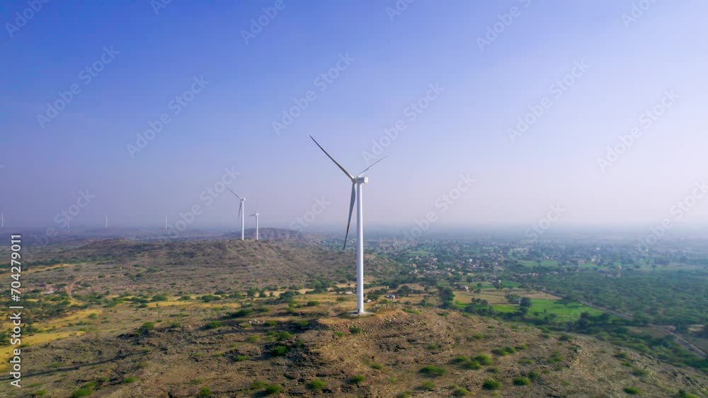 Aerial drone shot flying away from windmill wind turbine generators in Jaisalmer Rajasthan Gujarat showing alternate renewable energy sources in thar desert and aravalli range Aerial drone shot flying away from windmill wind turbine generators in Jaisalmer Rajasthan Gujarat showing alternate renewable energy sources in thar desert and aravalli range