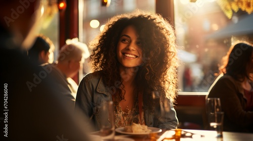 Smiling woman with curly hair sitting in a restaurant