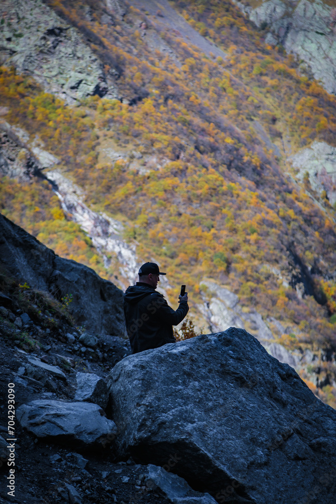 Man taking pictures of mountain landscape