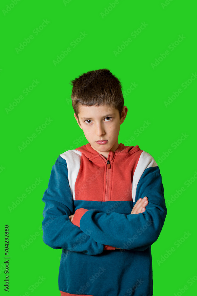 boy in a casual style feeling annoyed and showing sad expression on green background. boy in a casual style feeling annoyed and showing sad expression on green background.