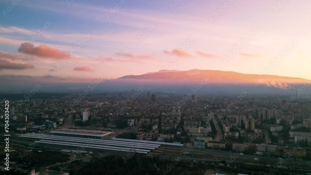 Aerial drone shot of the cityscape of the capital of Bulgaria - Sofia. Sunny blue sky foggy view towards the Vitosha mountain with the city center in the foreground. Misty footage of the skyline.
Aerial drone shot of the cityscape of the capital of Bulgaria - Sofia. Sunny blue sky foggy view towards the Vitosha mountain with the city center in the foreground. Misty footage of the skyline.