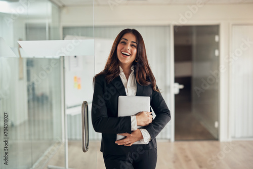 Laughing businesswoman standing at the door of an office boardroom photo