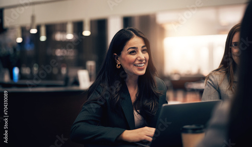 Businesswoman laughing during a meeting with colleagues in a hotel lobby