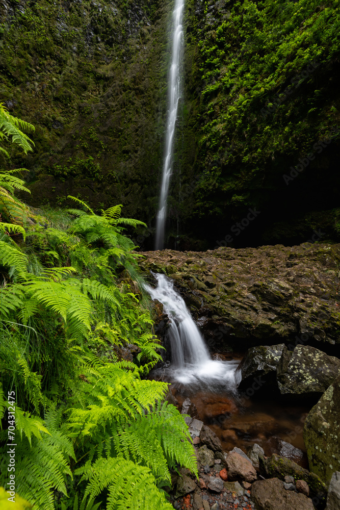Vertical photograph of a small cascade under the main waterfall of Caldeirao Verde valley. Popular tourist destination at the end of levada trail at Madeira Island, Portugal, Europe.