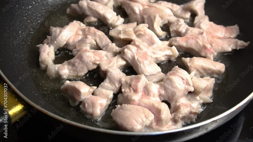 Pork meat cut into pieces is fried in a frying pan in sizzling oil. Suitable for home cooking content, recipe videos and cooking skills.