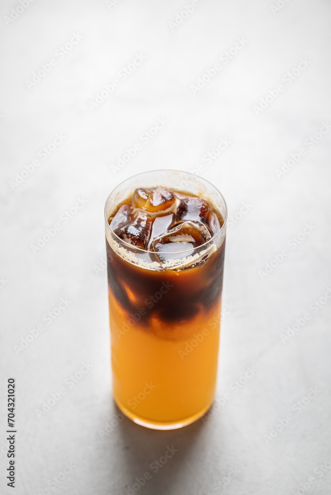 Coffee with orange juice bumble in a glass glass, on a gray background Coffee with orange juice bumble in a glass glass, on a gray background