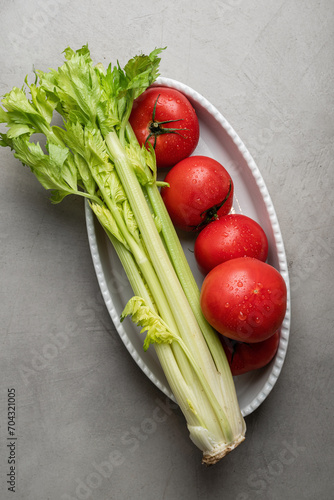 Fresh tomatoes and celery on a white plate. Healthly food
