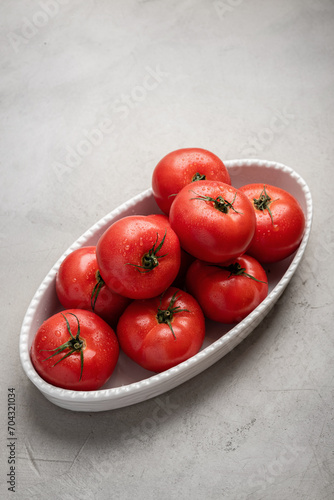 Large plate of fresh tomatoes on a concrete background. Healthly food