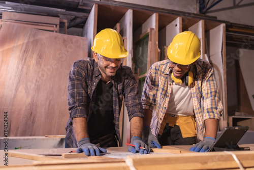 Young affrican american and white men carpenter labor, craftman working in wood workshop together, looking. Timber industry and furniture industry.