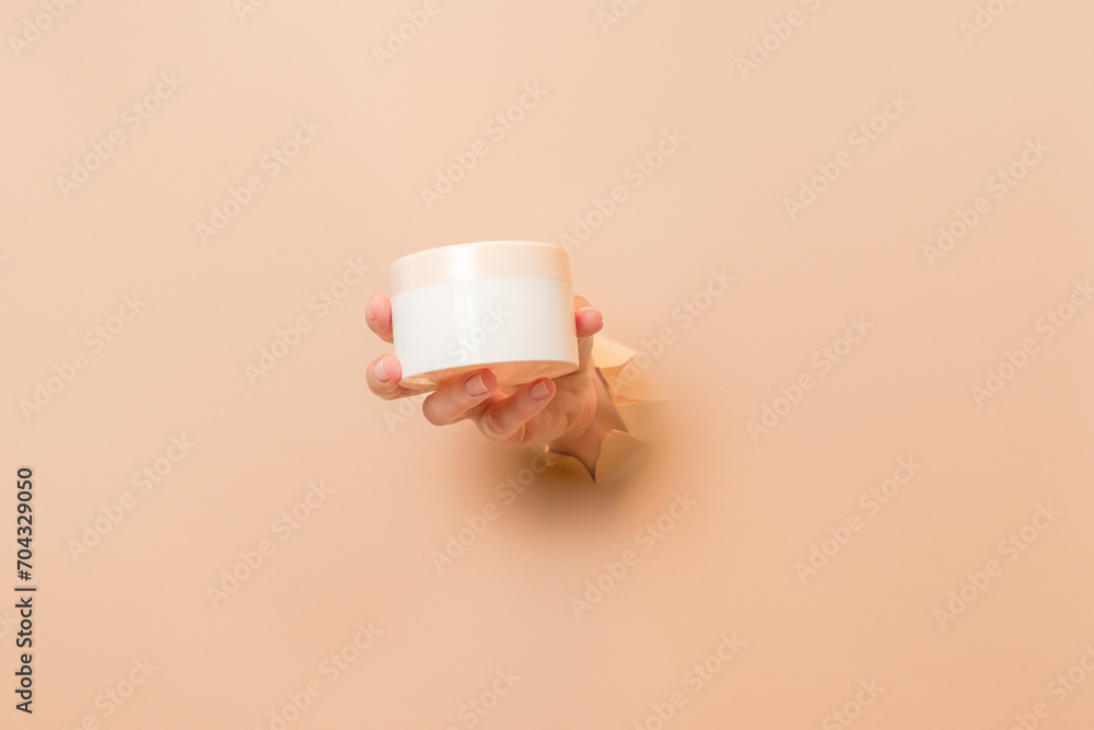 White cosmetic jar for face or skin cream in hand. Packaging for cosmetic beauty product, luxury makeup container, spa