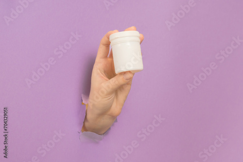 Cosmetic container in female hand. Cosmetic beauty packaging