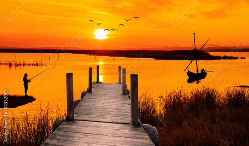anaranjado amanecer en el lago con un embarcadero