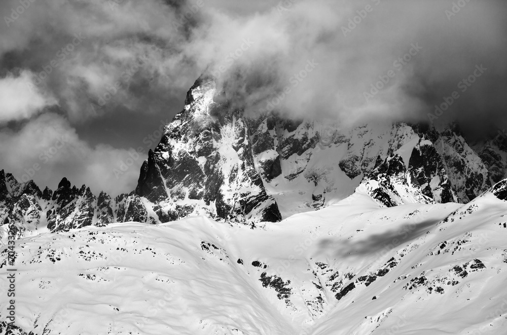 Black and white view on mount Ushba in fog at sun winter day before storm