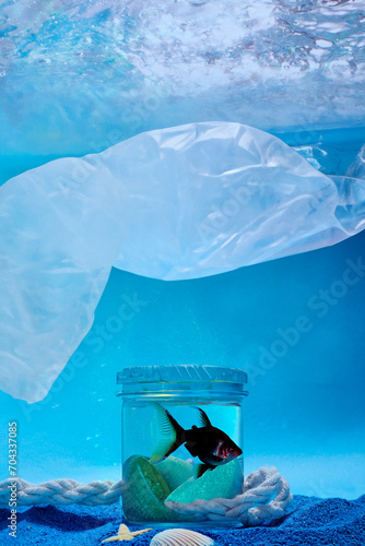 Plastic Pollution Concept. Fish in a glass jar