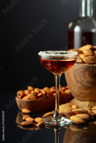 Italian liqueur Amaretto with almonds nuts on a black background.