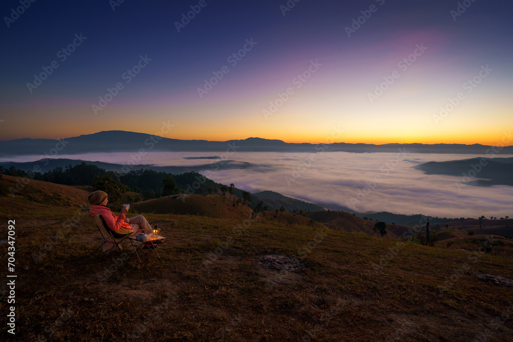 Pretty Asian Woman is happy with the beautiful scenery of the sea of mist in the morning at the Car Camping site with a viewpoint of is fresh nature of the top of Mountain Chiang Mai, Thailand. Pretty Asian Woman is happy with the beautiful scenery of the sea of mist in the morning at the Car Camping site with a viewpoint of is fresh nature of the top of Mountain Chiang Mai, Thailand.
