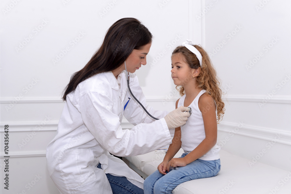 Female doctor smiling and giving medical examination to little girl in clinic Female doctor smiling and giving medical examination to little girl in clinic