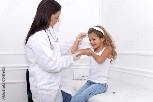 Female doctor smiling and giving medical examination to little girl in clinic