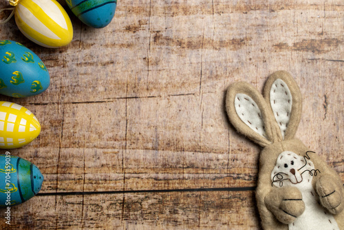 Easter Bunny and Colorful easter eggs on wooden background with copy space © SLindenau