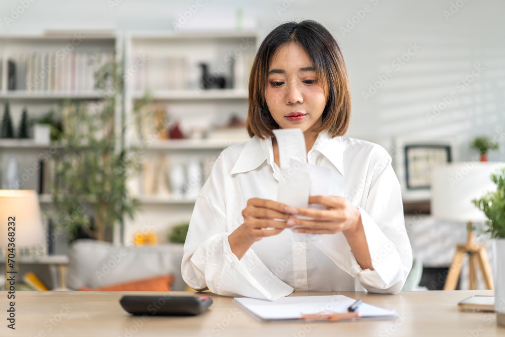 Smiling asian woman using calculator and calculate bills on laptop, paying bill, credit card, finance, tax, vat, credit card, payment, tax refund, budget, debt, money.financial and accounting concept Smiling asian woman using calculator and calculate bills on laptop, paying bill, credit card, finance, tax, vat, credit card, payment, tax refund, budget, debt, money.financial and accounting concept