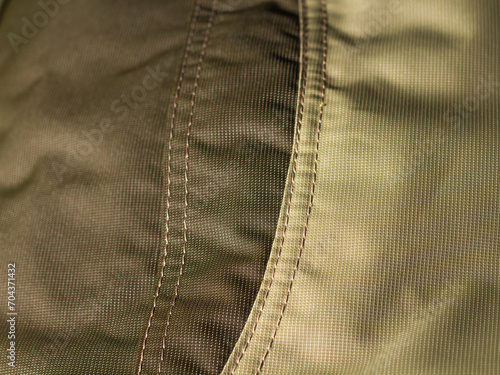 protective work clothes in beige and brown colors. Factory stitches on thick fabric. Close-up texture