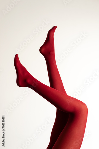 Cropped picture of gorgeous sexy lady in elegant colorful red tights isolated over white background.