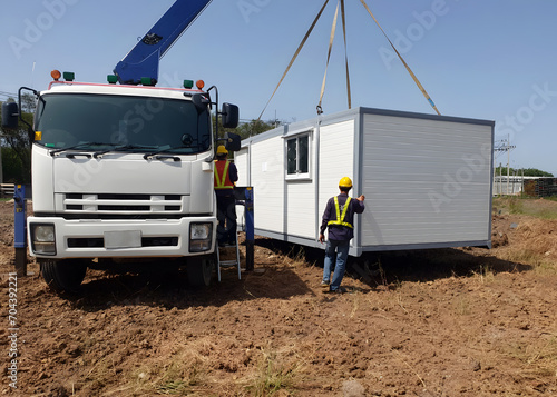 The Crane trucks transport the mobile office buildings or container site office for installation in the construction site area, project mobilization.