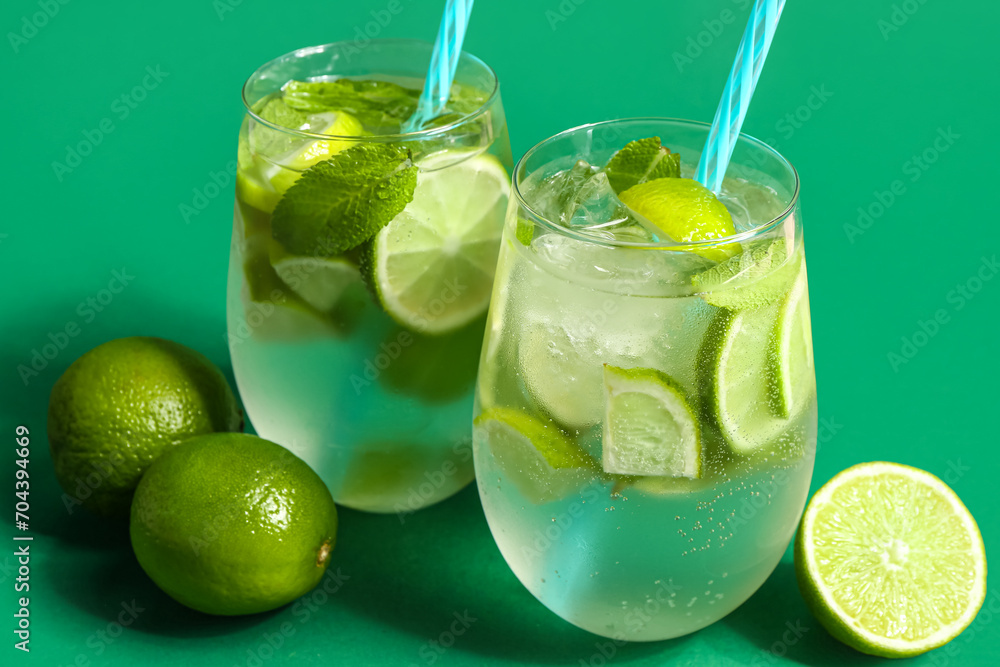 Glasses of cold mojito and lime on green background Glasses of cold mojito and lime on green background