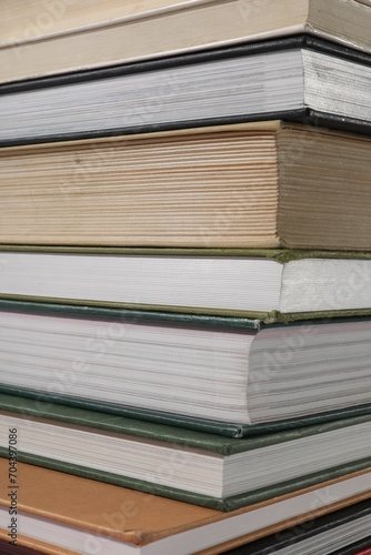 Stack of many different hardcover books as background, closeup