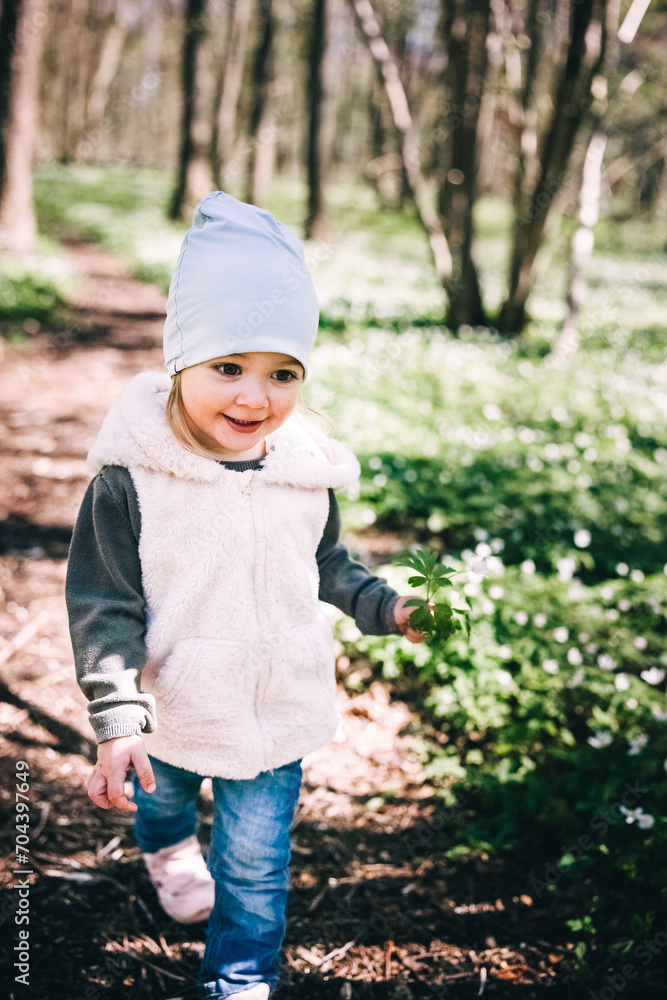 Small girl runs in the forest covered with anemones Small girl runs in the forest covered with anemones