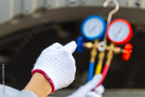 Repairman holding monitor tool to check and fixed car air conditioner system, Technician man checks car air conditioning system refrigerant recharge photo